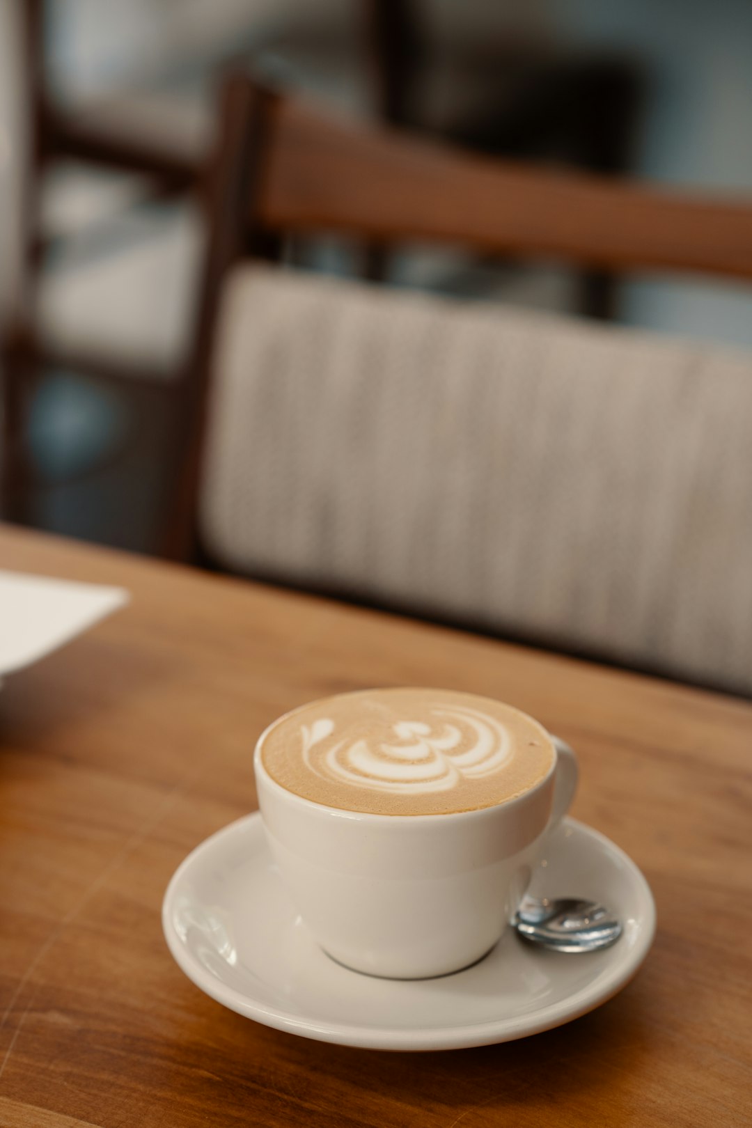 a-cup-of-coffee-sitting-on-top-of-a-wooden-table-krqxyjicqr0